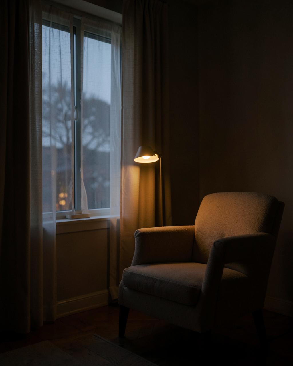 夜晚窗邊嘅安靜房間,一盞暖燈同一張空櫈